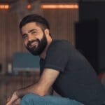 Young attractive guy sitting relaxing on a sofa in his loft office